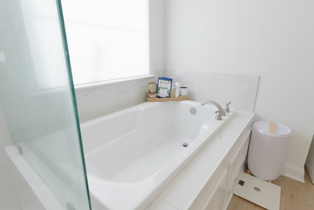 bathroom featuring a garden tub and toilet