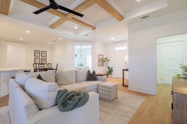 living area with light wood-style flooring, coffered ceiling, visible vents, ornamental molding, and beamed ceiling