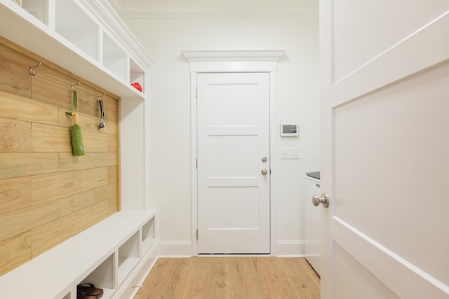 mudroom featuring crown molding, baseboards, and wood finished floors