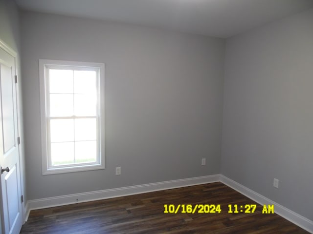 empty room featuring dark hardwood / wood-style flooring and a healthy amount of sunlight