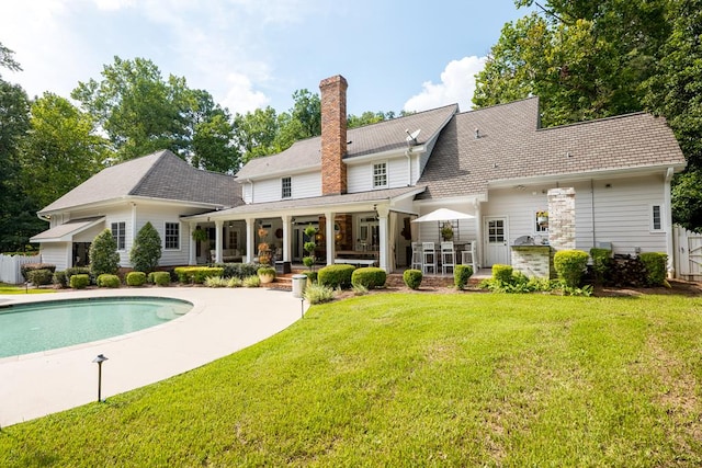 793 Lake Laurie Dr, Valdosta, GA 31605 - rear view of house with a fenced in pool, fence, a yard, and a chimney