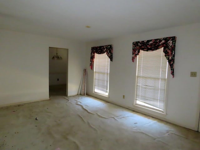 unfurnished room with a notable chandelier