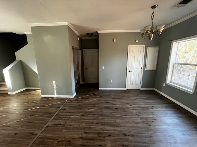 interior space with dark wood-type flooring, crown molding, and an inviting chandelier