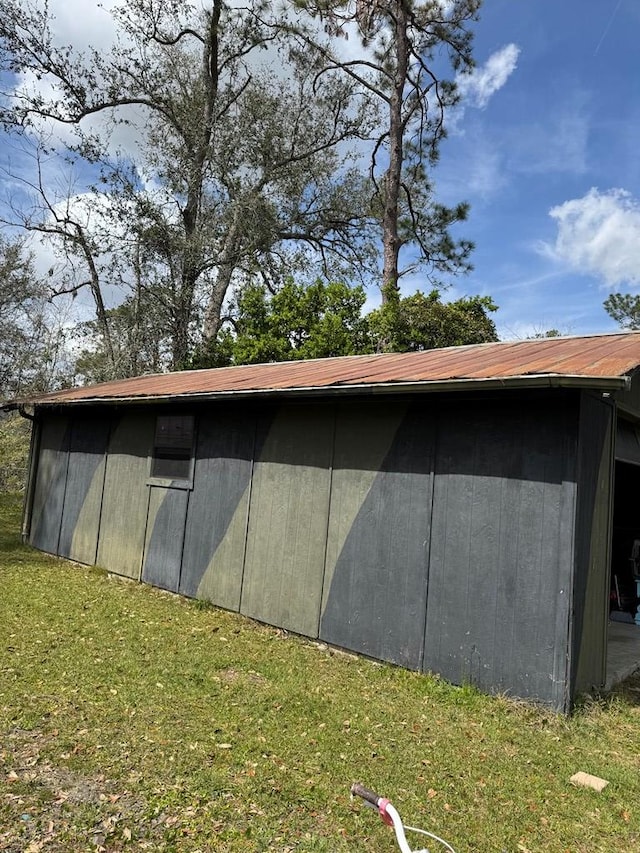 view of side of home with an outbuilding and a lawn