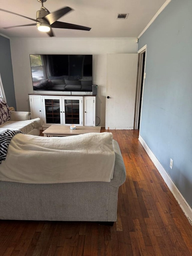 living room with visible vents, baseboards, ornamental molding, a ceiling fan, and wood-type flooring