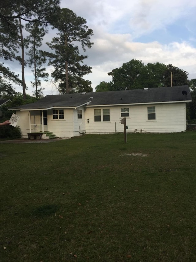 rear view of house with a yard