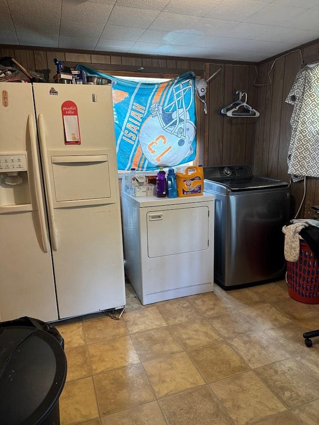 laundry room featuring washing machine and dryer, wood walls, and laundry area