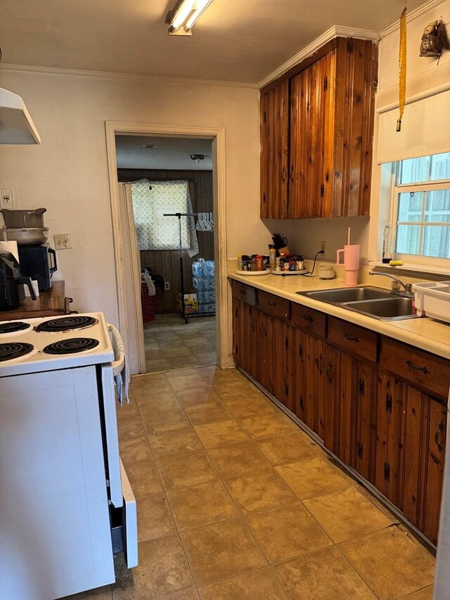 kitchen featuring a sink, ornamental molding, light countertops, and white range with electric cooktop