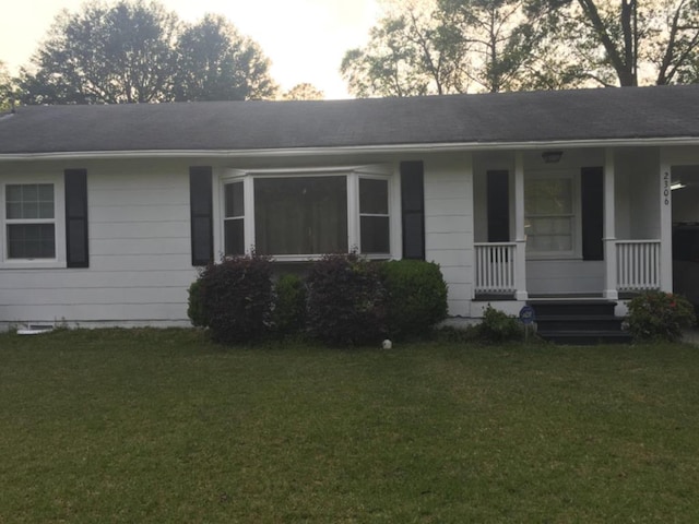 single story home with a front yard and covered porch