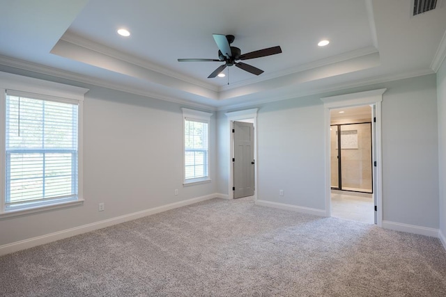 unfurnished bedroom with ornamental molding, a raised ceiling, visible vents, and light carpet