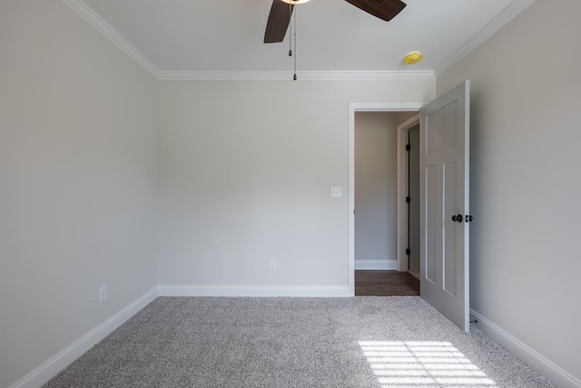 unfurnished room with ornamental molding, carpet flooring, baseboards, and a ceiling fan