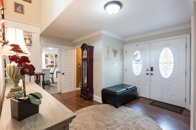 entryway with crown molding, dark wood-type flooring, and a textured ceiling