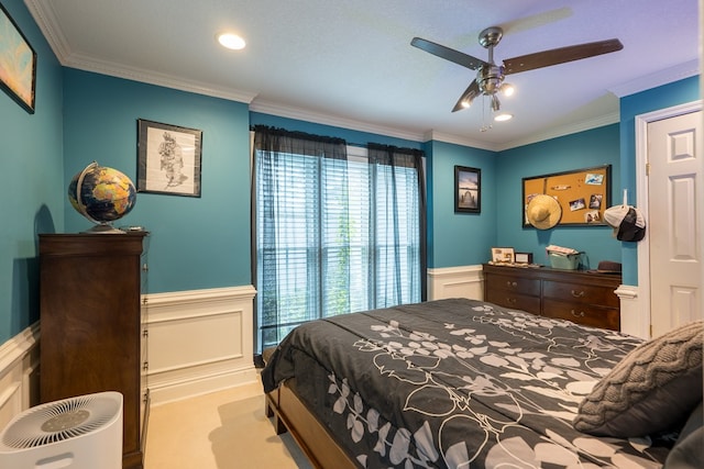 carpeted bedroom featuring crown molding and ceiling fan