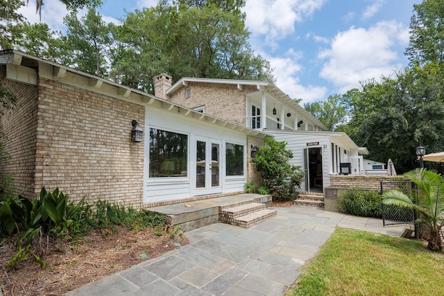 back of property with a patio area and french doors