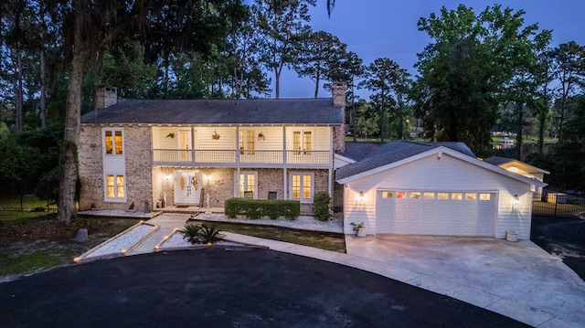 view of front facade featuring a garage and a balcony