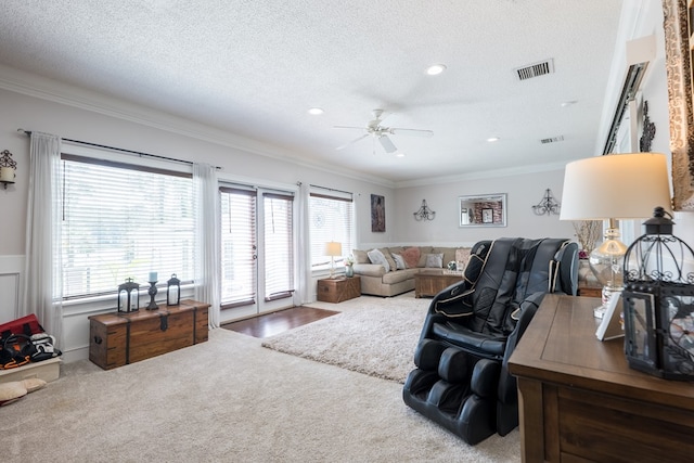 living room featuring a wealth of natural light, ornamental molding, and a textured ceiling