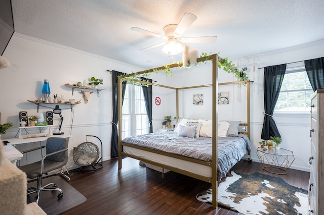 bedroom featuring ceiling fan, crown molding, dark hardwood / wood-style floors, and a textured ceiling