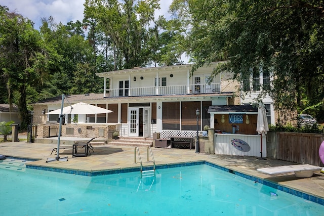 rear view of house with a bar, a patio, and a balcony