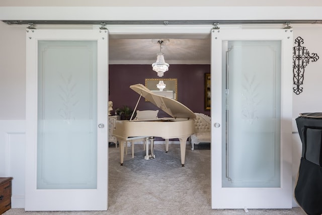 misc room featuring carpet floors, ornamental molding, and a barn door