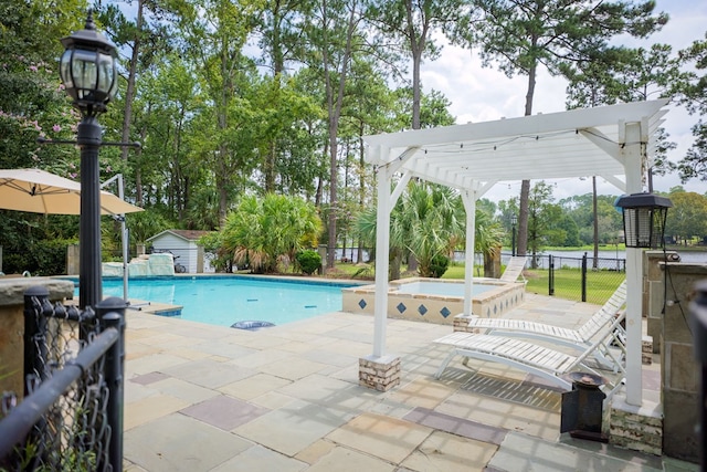 view of swimming pool with an in ground hot tub, a patio area, a shed, and a pergola