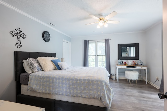 bedroom with crown molding, ceiling fan, a textured ceiling, and light wood-type flooring