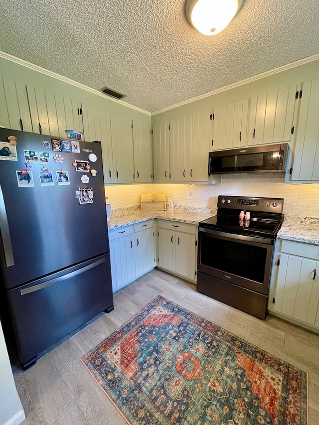 kitchen with range hood, decorative backsplash, stainless steel appliances, visible vents, and a textured ceiling