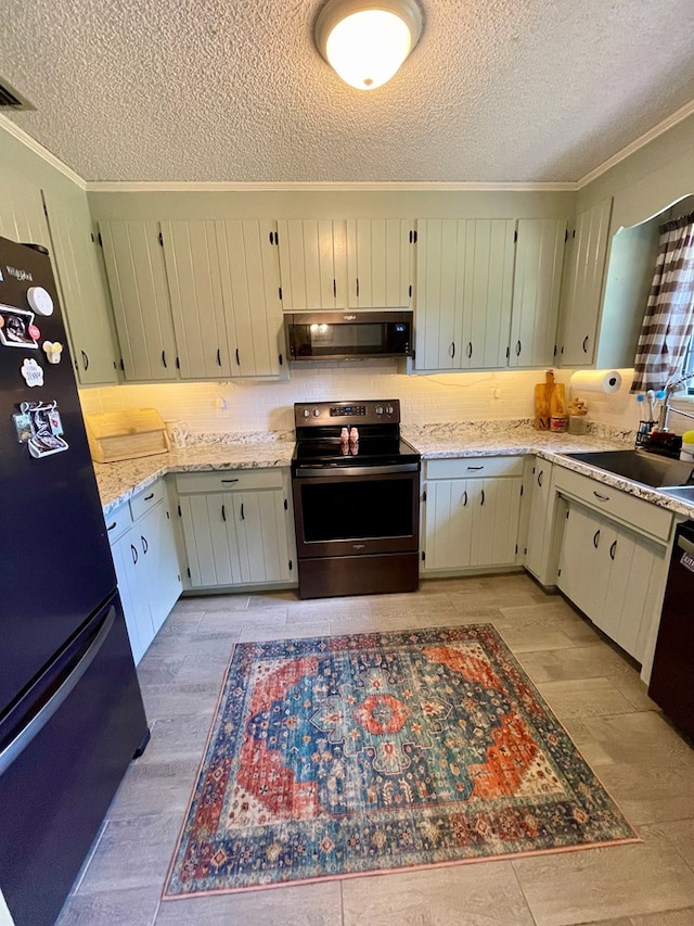 kitchen with black appliances, light wood finished floors, a sink, a textured ceiling, and crown molding