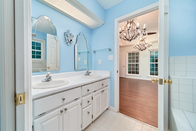 bathroom featuring tile patterned flooring, vanity, and an inviting chandelier