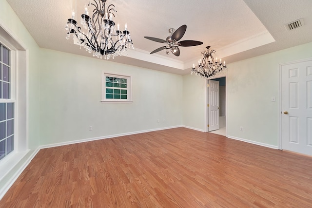 spare room featuring hardwood / wood-style floors, a tray ceiling, a textured ceiling, and a chandelier