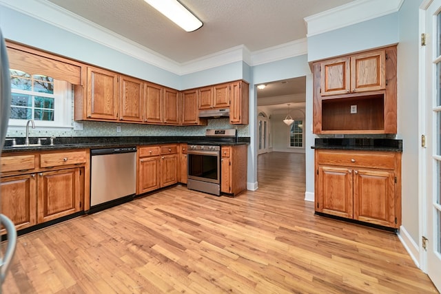 kitchen with tasteful backsplash, sink, stainless steel appliances, and light hardwood / wood-style floors