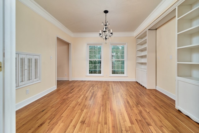 unfurnished dining area with built in shelves, ornamental molding, light hardwood / wood-style floors, and a notable chandelier