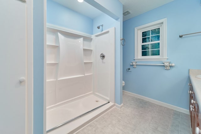 bathroom featuring walk in shower, toilet, and a textured ceiling