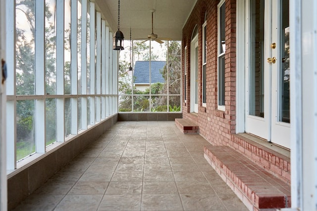 unfurnished sunroom featuring plenty of natural light and ceiling fan