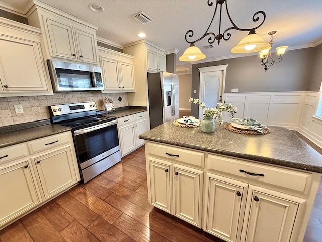 kitchen featuring decorative light fixtures, a notable chandelier, dark hardwood / wood-style floors, crown molding, and appliances with stainless steel finishes