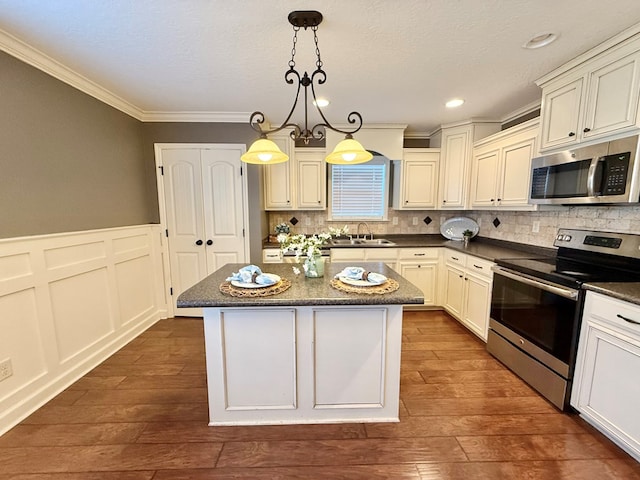 kitchen featuring sink, a center island, hanging light fixtures, and appliances with stainless steel finishes