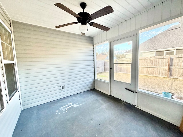 unfurnished sunroom featuring ceiling fan