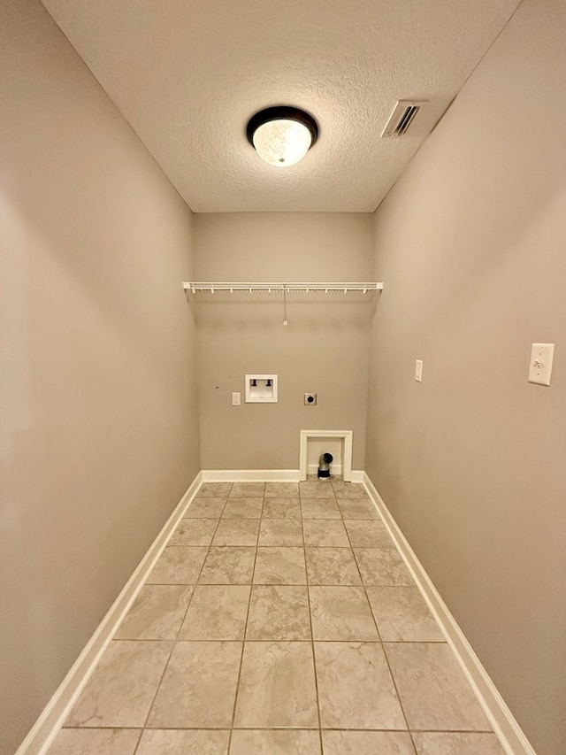 laundry area with a textured ceiling, hookup for a washing machine, tile patterned flooring, and electric dryer hookup