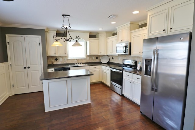 kitchen featuring sink, hanging light fixtures, a kitchen island, dark hardwood / wood-style flooring, and appliances with stainless steel finishes