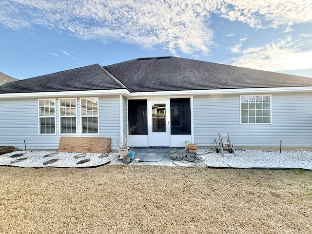 rear view of house featuring a yard, a sunroom, and a patio