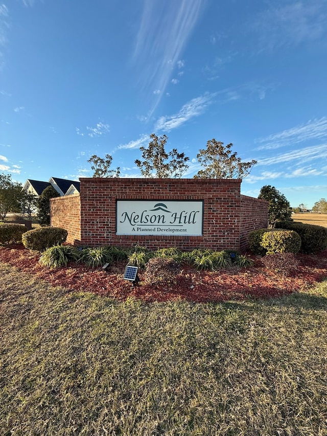 community / neighborhood sign featuring a lawn