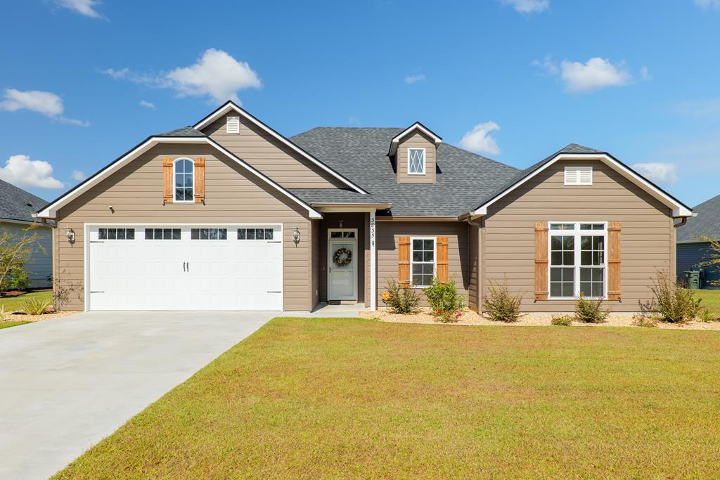 view of front of home with a front yard and a garage