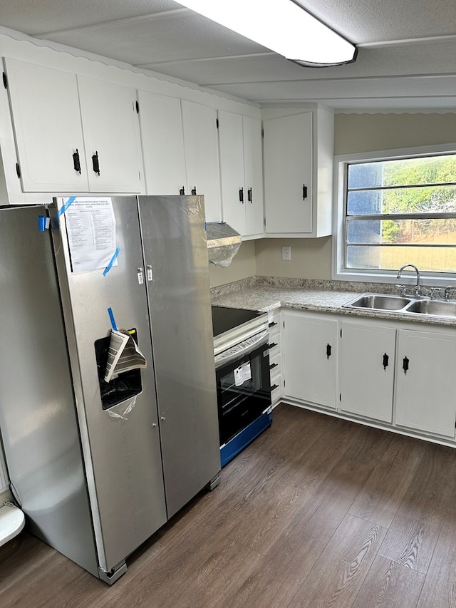 kitchen featuring stainless steel fridge, dark hardwood / wood-style flooring, electric range oven, sink, and white cabinetry