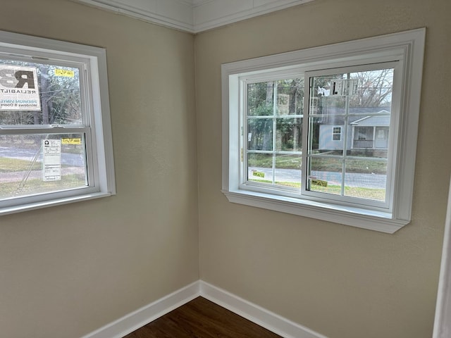 spare room with hardwood / wood-style flooring, a wealth of natural light, and crown molding