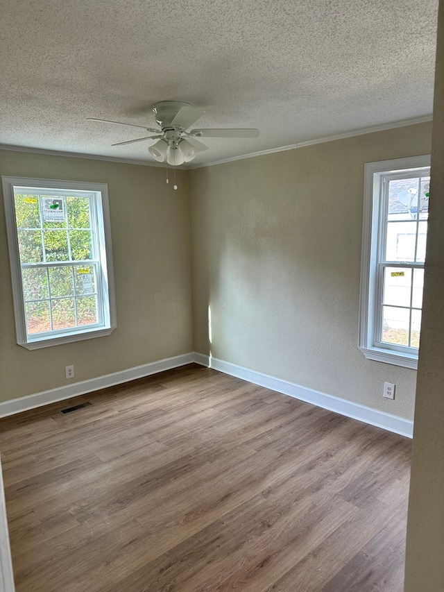 spare room featuring ceiling fan, ornamental molding, a textured ceiling, and light hardwood / wood-style flooring