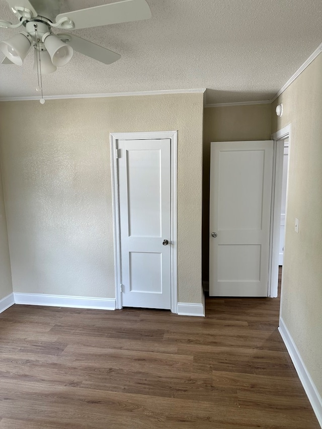 unfurnished room with a textured ceiling, dark hardwood / wood-style flooring, ceiling fan, and crown molding