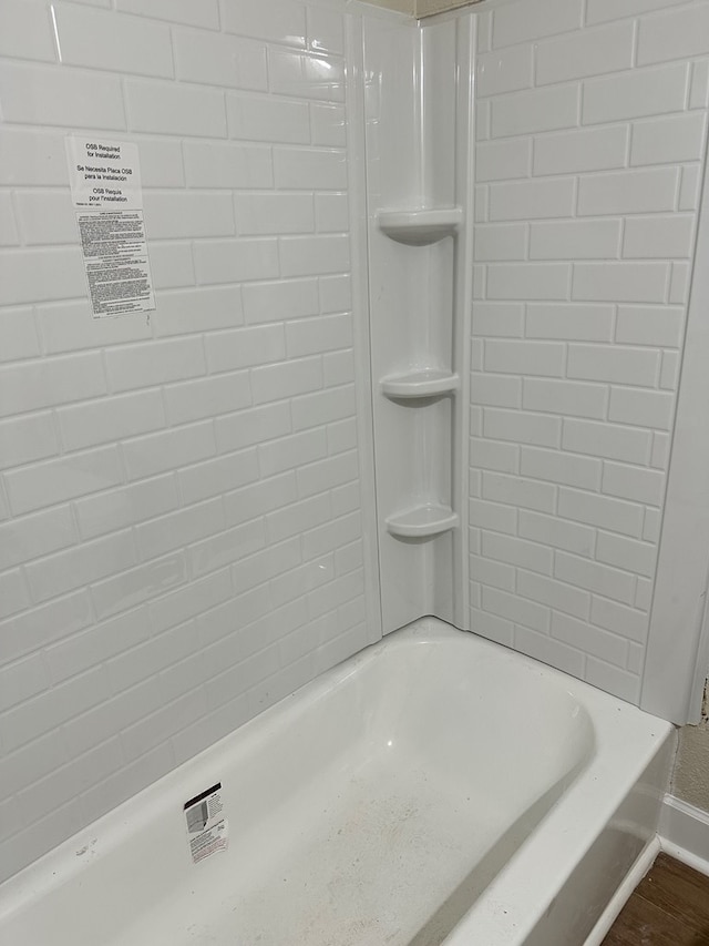 bathroom featuring bathing tub / shower combination and hardwood / wood-style flooring