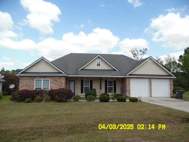 traditional home with covered porch, driveway, a front yard, an attached garage, and stone siding