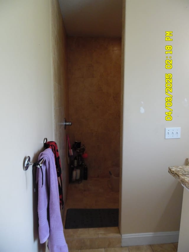 full bathroom with tile patterned floors and a tile shower