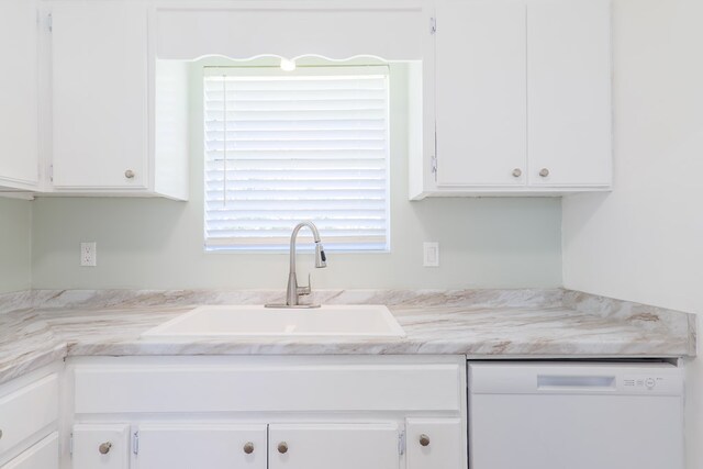 kitchen with white cabinets, white dishwasher, and sink