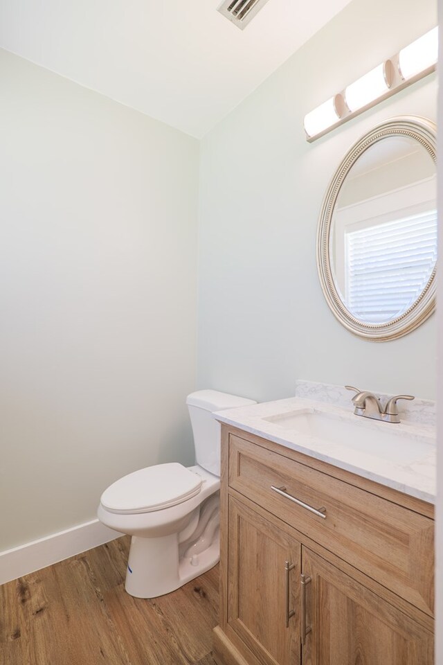 bathroom with vanity, hardwood / wood-style flooring, and toilet